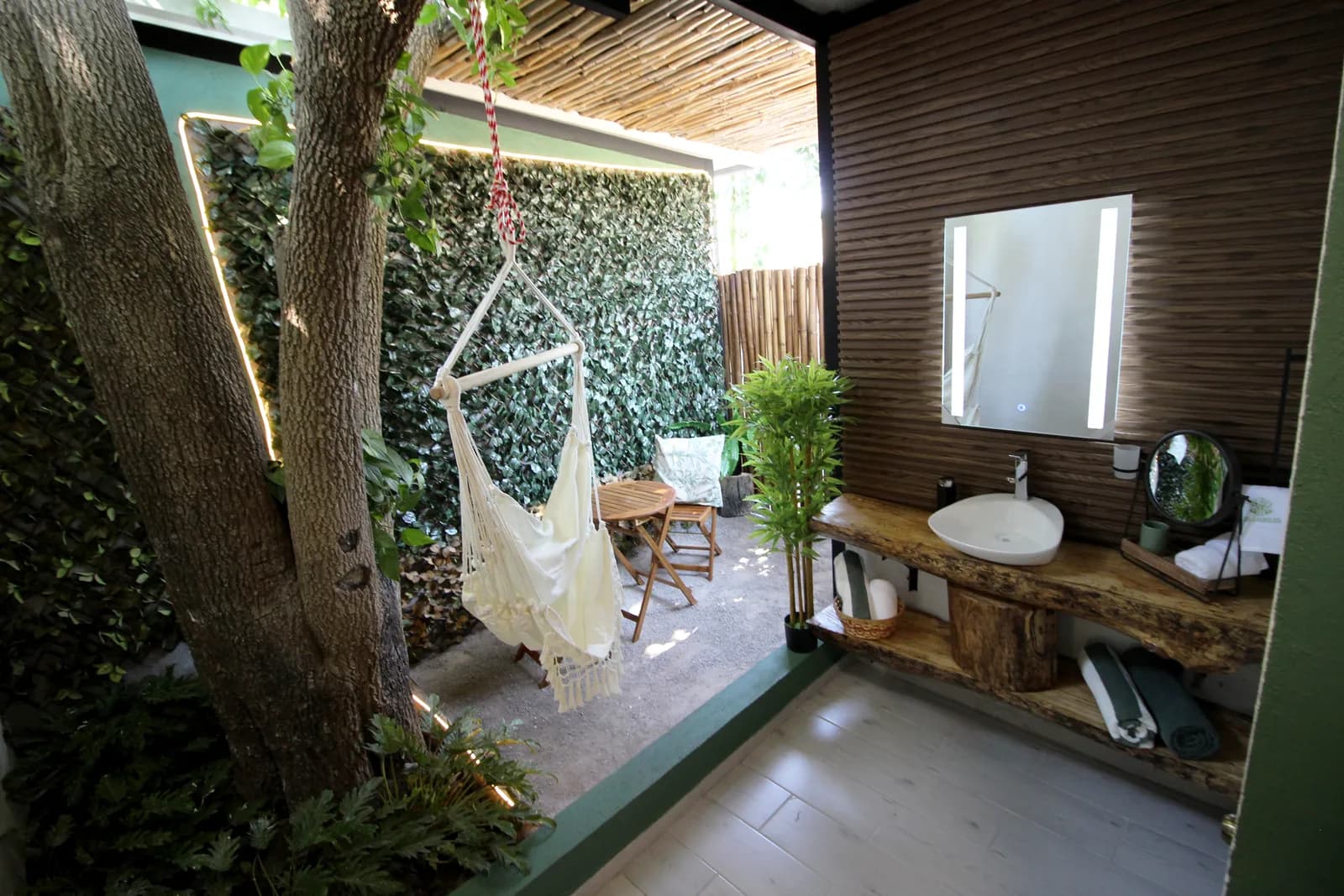 Rincón exterior privado con hamaca y muro verde en Casa Laureles